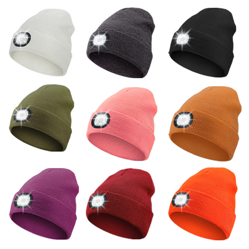 Set of colorful beanies with LED lights on a white background