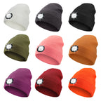Set of colorful beanies with LED lights on a white background